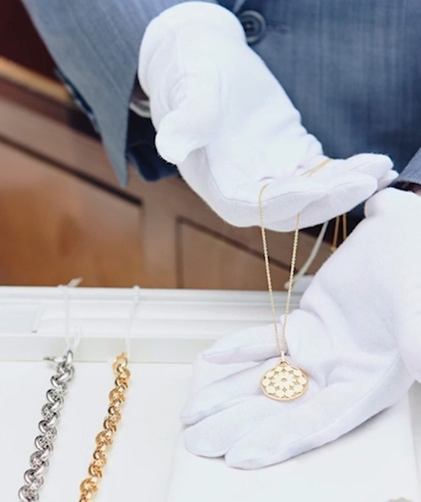 a jeweller holds a gold necklace