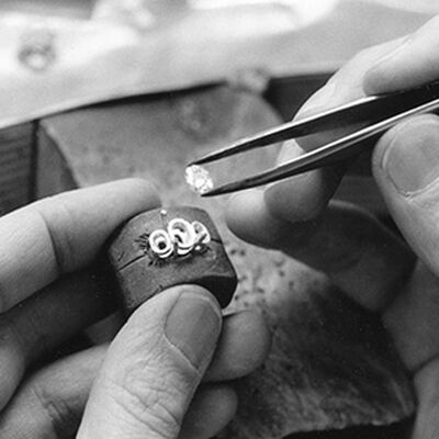 a jeweller places a stone in a ring