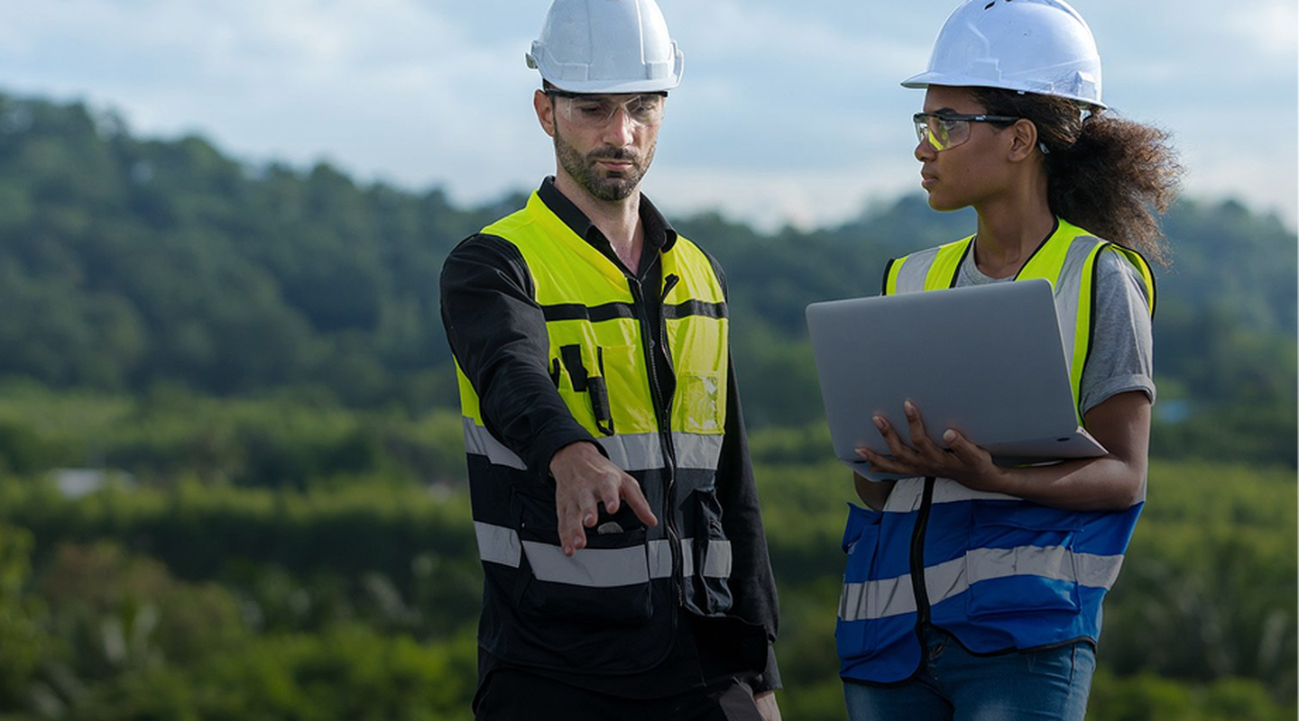 A male and female engineer review a project plan