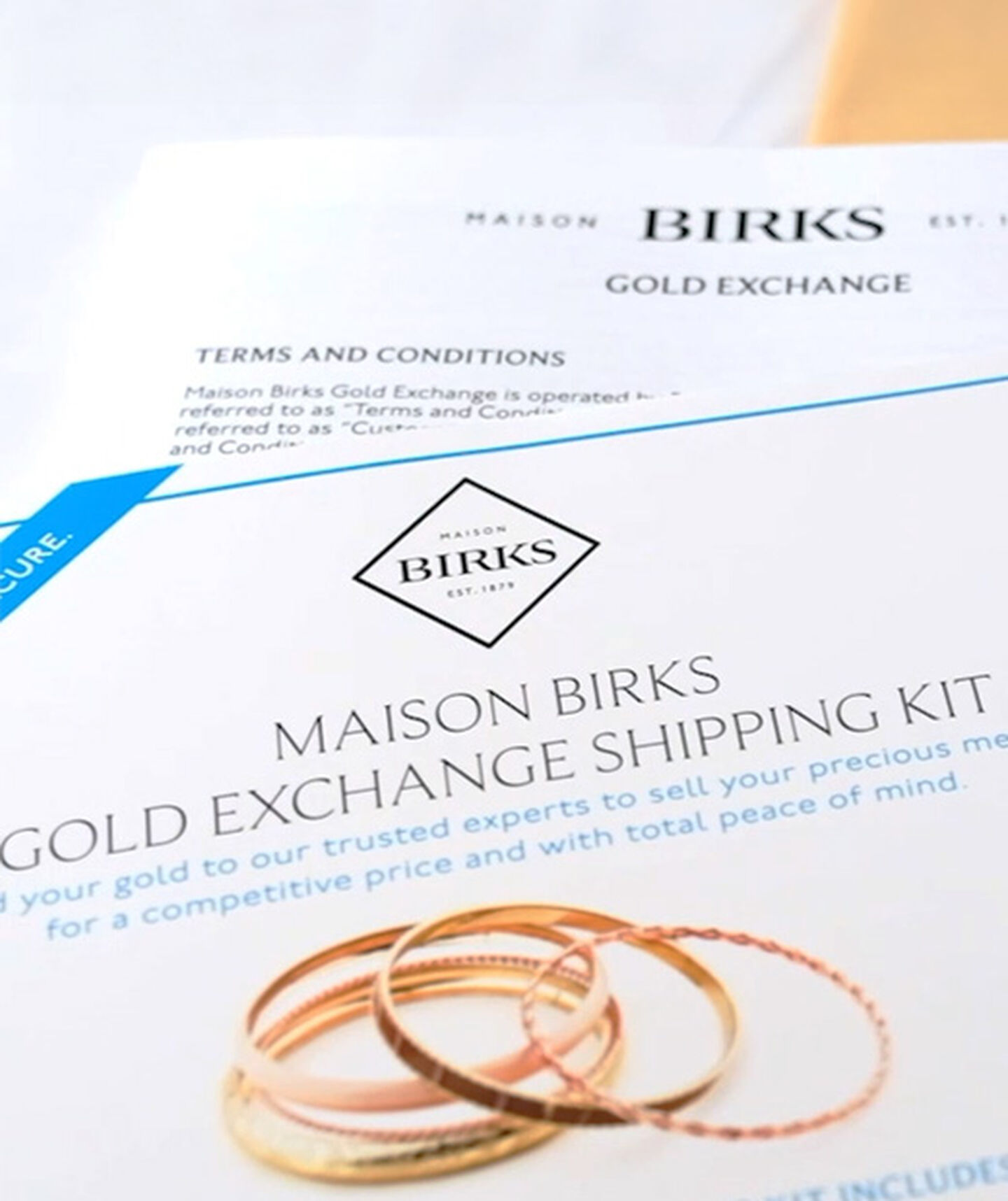 a stack of gold jewellery on a printed shipping label